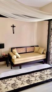 a living room with a couch and a cross on the wall at Pico De Loro 2BR Carola B Unit with Lagoon View in Nasugbu