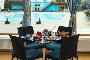 uma mesa com comida e vista para uma piscina em Aqua Hotel em Děčín