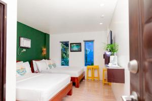 a hotel room with two beds and a door at DENGI INN EL NIDO in El Nido