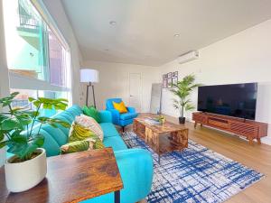 a living room with a blue couch and a tv at Hollywood/Thai Town Courtyard Apartment in Los Angeles