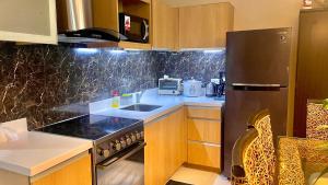 a kitchen with a black refrigerator and a sink at Pico De Loro 2BR Carola B Unit with Lagoon View in Nasugbu