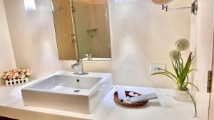 a bathroom with a white sink and a mirror at Pico De Loro 2BR Carola B Unit with Lagoon View in Nasugbu