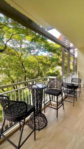 a group of chairs and tables on a balcony at Pico De Loro 2BR Carola B Unit with Lagoon View in Nasugbu
