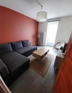 een woonkamer met een bank en een salontafel bij Charmante maison 3 chambres avec cour in Lille