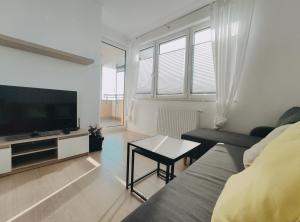 a living room with a couch and a television at Dobrego Pasterza 120D by Homeprime in Kraków