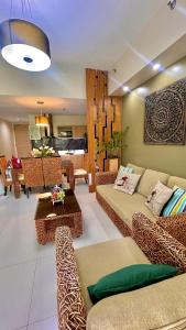 a living room with couches and a dining room at Pico De Loro 2BR Carola B Unit with Lagoon View in Nasugbu