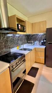 a kitchen with a sink and a stove top oven at Pico De Loro 2BR Carola B Unit with Lagoon View in Nasugbu