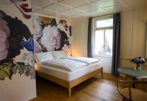 - une chambre avec un lit orné d'une peinture murale dans l'établissement FLÜHLI Hotel Kurhaus, à Flühli