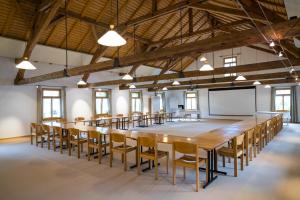 une grande salle de conférence avec une grande table et des chaises dans l'établissement FLÜHLI Hotel Kurhaus, à Flühli