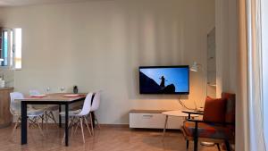 a living room with a table and a tv on the wall at Marina Apartment in Durrës