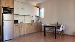 a kitchen with white cabinets and a table with chairs at Marina Apartment in Durrës