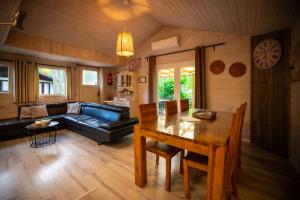 a living room with a table and a couch at Chalet de bosuil in Zutendaal