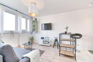 a living room with a couch and a tv at Olive City View Apartment in Wrocław