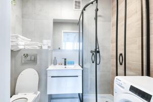 a bathroom with a shower and a toilet and a sink at Olive City View Apartment in Wrocław