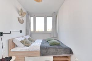 a small bedroom with a bed and a window at Olive City View Apartment in Wrocław