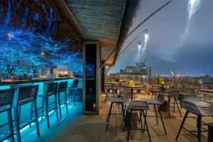 a bar with chairs and tables and a view of the city at Le Jardin Hotel Haute Couture in Hanoi