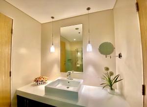a bathroom with a sink and a mirror at Pico De Loro 2BR Carola B Unit with Lagoon View in Nasugbu