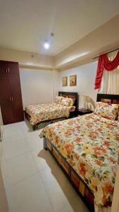 a bedroom with two beds and a window at Pico De Loro 2BR Carola B Unit with Lagoon View in Nasugbu