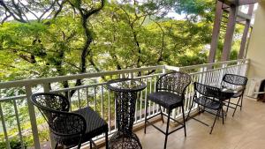 a porch with four chairs and a table on a balcony at Pico De Loro 2BR Carola B Unit with Lagoon View in Nasugbu