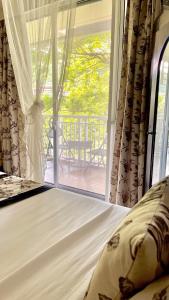 a bedroom with a bed and a large window at Pico De Loro 2BR Carola B Unit with Lagoon View in Nasugbu