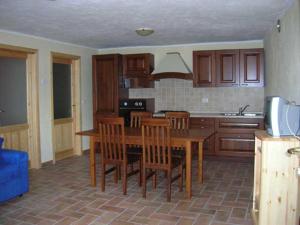 a kitchen with a wooden table and wooden chairs at Appartamento in pieno relax in Saint Nicolas
