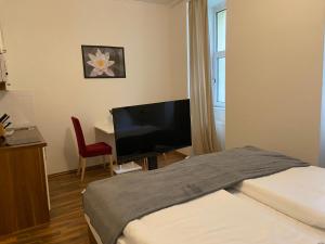 Dormitorio con cama, escritorio y TV en Grand Central Station Apartments I contactless check-in, en Viena