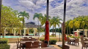 a restaurant with tables and chairs and a pool at Pico De Loro 2BR Carola B Unit with Lagoon View in Nasugbu