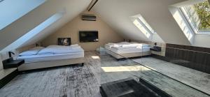 a attic bedroom with two beds and a tv at Lake Park in Zator