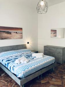 a bedroom with a large bed with blue and white sheets at Casa Emma 400 mt dal mare in Spotorno