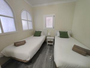 zwei Betten in einem Zimmer mit zwei Fenstern in der Unterkunft Los Nidos in San Bartolomé de Tirajana + 40 Fotos