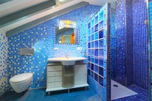 uma casa de banho em azulejos azuis com um lavatório e um WC em Green House em Reocín