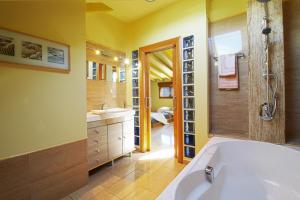 een badkamer met een bad, een douche en een wastafel bij Green House in Reocín