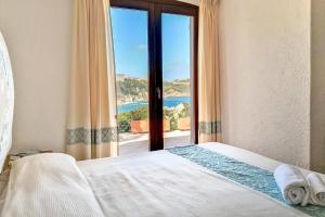 a bedroom with a bed with a view of the ocean at Villa Eleonora - Sea view in Santa Teresa Gallura