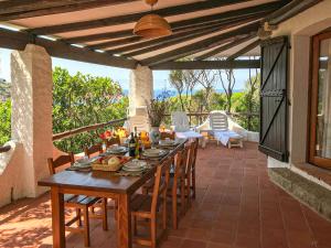 a wooden table and chairs on a patio at Villa Eleonora - Sea view in Santa Teresa Gallura