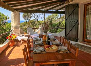 a wooden table with fruit and wine on a patio at Villa Eleonora - Sea view in Santa Teresa Gallura +19 photos
