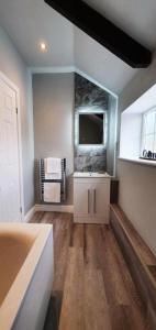 a bathroom with a sink and a tv on the wall at The George Country Inn, Wath in Wath