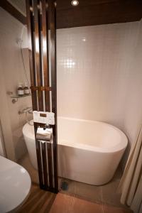a bathroom with a bath tub and a toilet at HOTEL Clam Chowder in Kyoto