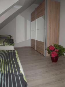 シャルボイツにあるFerienwohnung Angelika _ Peter Kelのベッドルーム1室(ベッド1台付)、鉢植えのキャビネットが備わります。