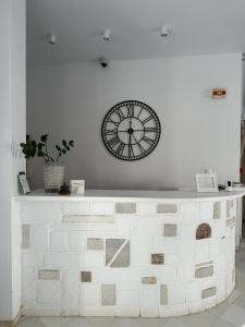 a clock on the wall above a white wall at Artemis Hotel in Antiparos