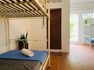 1 dormitorio con litera y colcha azul en Villa Martial Arts Gym & Guesthouse en Phnom Penh