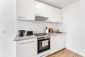 a kitchen with white cabinets and a stove at Casa Bergstraße 3 in Bensheim