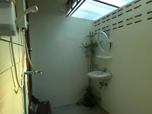 a bathroom with a sink and a mirror at บ้านปุณยาพร โฮมสเตย์ in Amphawa