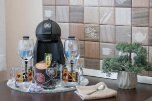 a table with wine glasses and a coffee maker at Venezia Studio 2 in Oradea