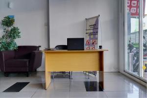 a wooden desk in a room with a laptop on it at OYO Life 92889 Apartement Grand Sentraland Karawang By A.t Room in Karawang