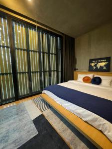 a bedroom with a large bed and large windows at T House Cha-Am 