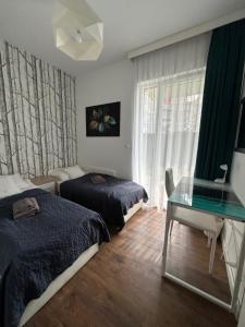 1 dormitorio con 2 camas y mesa de cristal en Forest Apartment, en Augustów