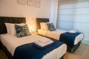 a bedroom with two beds with towels on them at Quattro Beachfront Sea View Ap 53 in Larnaka