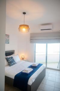 a bedroom with a bed and a large window at Quattro Beachfront Sea View Ap 53 in Larnaka