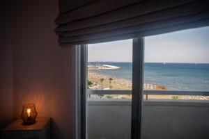 a room with a window with a view of a beach at Quattro Beachfront Sea View Ap 53 in Larnaka