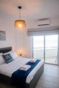 a bedroom with a large bed with a large window at Quattro Beachfront Sea View Ap 53 in Larnaka
